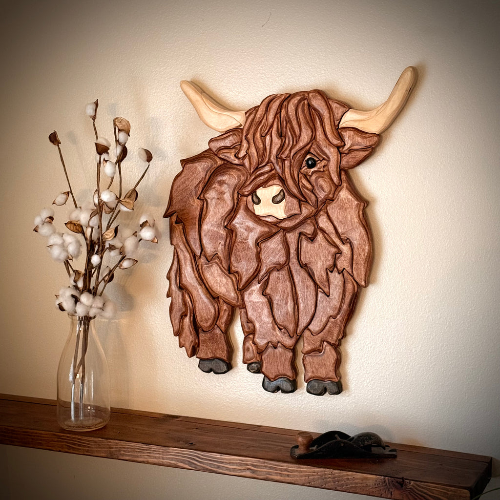Handmade Highland cow wooden wall art displayed on wall, showcasing rustic charm for highland cow home decor.