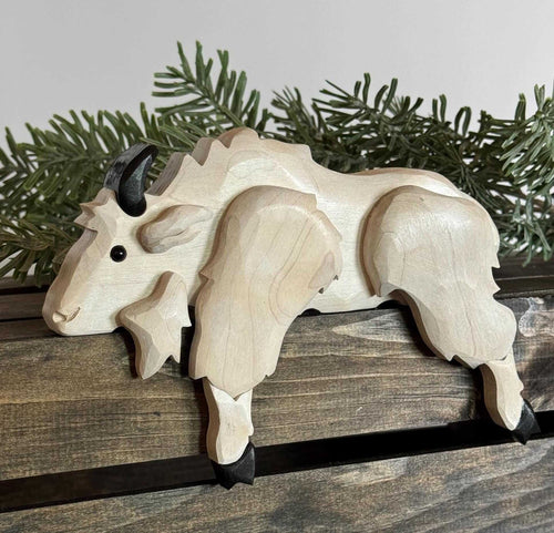 Handmade Wooden Mountain Goat Shelf Sitter | Rustic Cabin Decor sitting on a rustic wooden shelf with greenery.